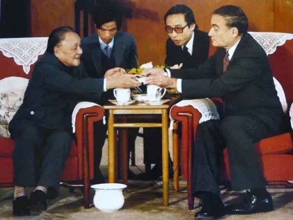 ·担任邓小平同志(左)翻译时的高志凯(后排右)。(受访者供图)